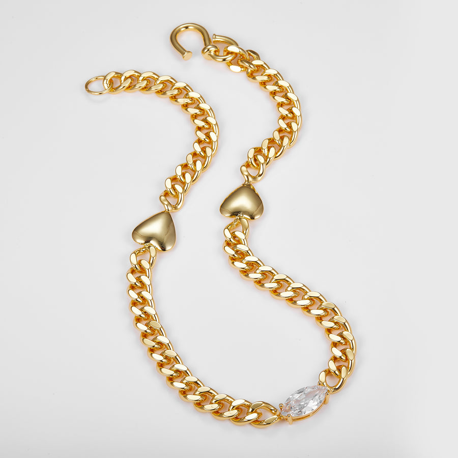 Gold chain necklace with heart-shaped clasps on a light gray background