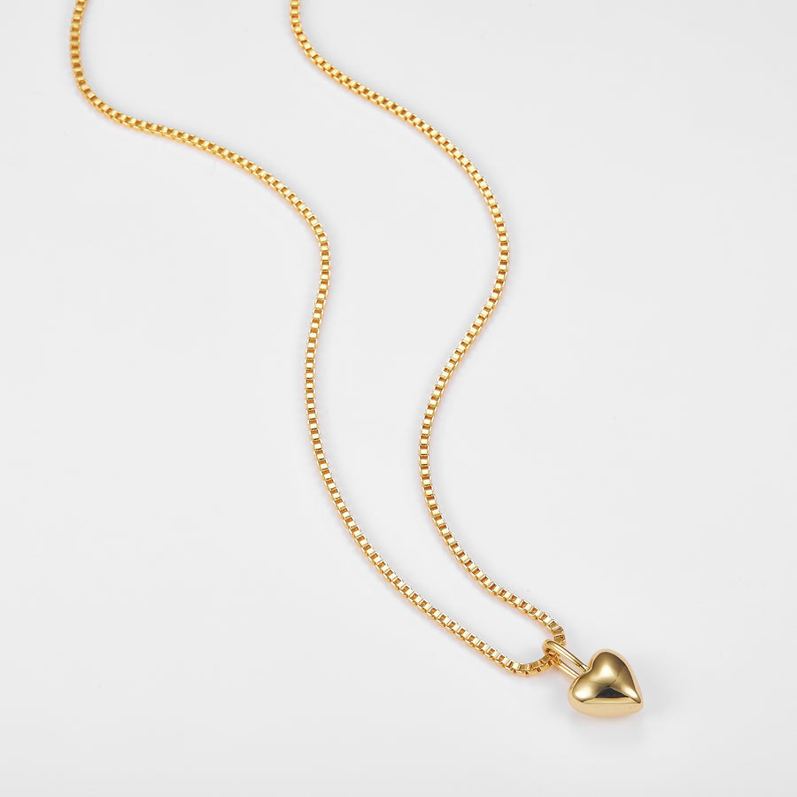 Gold necklace with a heart pendant on a white background