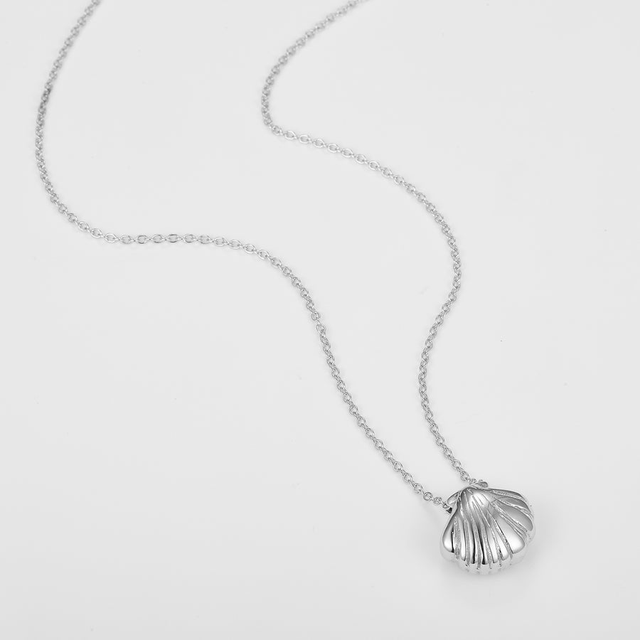 Silver shell pendant necklace on a light gray background